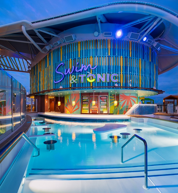 Adults Only Kreuzfahrt auf der 'Icon of the Seas' beim REISEBÜRO Wache, Erfurt, buchen; im Bild: Die beleuchtete Poolbar 'Swim & Tonic' samt beleuchtetem Pool in der Dämmerung