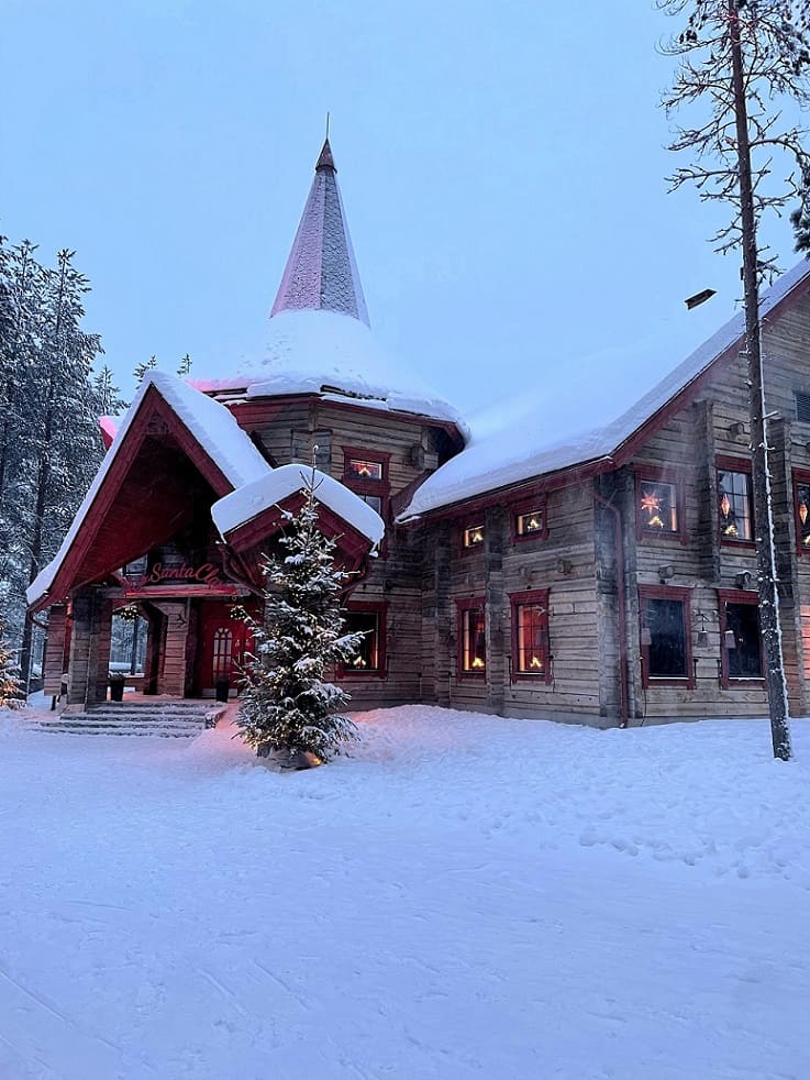 Finnland Urlaub Weihnachtsmann - bestens beraten beim REISEBÜRO Wache; im Bild: verschneites Haus mit Weihnachtsschmuck in Rovamieni in Finnland in der Dämmerung.