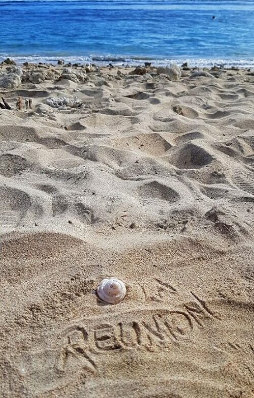 Strandurlaub La Réunion im Indischen Ozean buchen beim REISEBÜRO Wache, Erfurt; im Bild: heller Sandstrand in den die Worte 