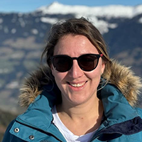 Winterurlaub buchen in Finnland beim REISEBÜRO Wache, Erfurt; im Bild: Reiseberaterin Sabine Amberg mit Sonnenbrille und Winterjacke vor Bergen